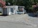 Mobile home with screened porch and an American flag at 113 Hummingbird Cir, New London, NC 28127