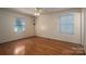 Light beige bedroom with wood floors, ceiling fan, and two windows at 1890 Rhyneland Rd, Lincolnton, NC 28092