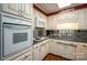 White kitchen cabinets, granite countertops, and built-in microwave at 1890 Rhyneland Rd, Lincolnton, NC 28092
