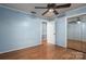 Light blue bedroom with wood floors, ceiling fan, and mirrored closet doors at 1890 Rhyneland Rd, Lincolnton, NC 28092