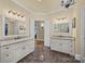 Elegant bathroom boasts double vanities, a large mirror, and marble flooring at 4364 Hager Mountain Ln, Iron Station, NC 28080