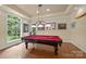 Game room includes a billiard table and large window overlooking the backyard at 4364 Hager Mountain Ln, Iron Station, NC 28080