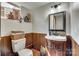 Small bathroom with a wood-paneled lower half, a pedestal sink, and a toilet at 164 Quiet Cove Rd, Mooresville, NC 28117