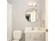 Small bathroom with a round mirror and white vanity at 348 S Laurel Ave, Charlotte, NC 28207