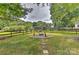Fire pit area in backyard, surrounded by trees and a fence at 13901 Phillips Rd, Matthews, NC 28105