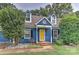 Blue house with yellow door, landscaping, and a two-car garage at 13901 Phillips Rd, Matthews, NC 28105