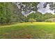 Open backyard space with mature trees and fence at 13901 Phillips Rd, Matthews, NC 28105