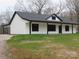 White house with black accents, covered porch, and landscaped lawn at 3910 Jenkins Rd, Clover, SC 29710