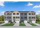 Four townhomes with garages, siding in various shades of blue and beige, and green lawns at 5597 Knox Ln, Kannapolis, NC 28081