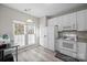 Bright eat-in kitchen features white cabinetry, stainless steel appliances, and vinyl flooring at 14508 Reese Blvd, Huntersville, NC 28078