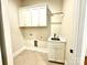 Convenient laundry room with upper cabinets and a utility sink at 310 Scalybark Trl, Concord, NC 28027