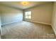 Spacious bedroom with carpeted floors and a large window at 310 Scalybark Trl, Concord, NC 28027
