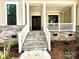 Inviting front porch with stone steps and railing at 310 Scalybark Trl, Concord, NC 28027