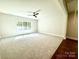 Large bedroom with carpeted floors, ceiling fan and a large window at 310 Scalybark Trl, Concord, NC 28027