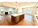 Open kitchen with island, stainless steel appliances, and hardwood floors at 310 Scalybark Trl, Concord, NC 28027