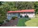 Gray house with red shutters, a red metal roof and a nicely landscaped yard at 4120 Statesville Blvd, Salisbury, NC 28147