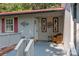 Covered porch with wicker chair and wreath, brick steps leading to the front door at 4120 Statesville Blvd, Salisbury, NC 28147