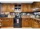 View of kitchen with wood cabinets, black stove and microwave at 4120 Statesville Blvd, Salisbury, NC 28147