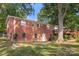 Brick home's backyard, showing a deck and large tree at 1573 Timberlake Dr, Shelby, NC 28150