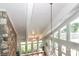 High ceilings with exposed beams, stone fireplace, and large windows offering abundant natural light at 3208 Sedgefield Rd, Statesville, NC 28625