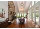 Bright dining room with hardwood floors, stone fireplace, and large windows at 3208 Sedgefield Rd, Statesville, NC 28625