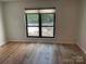 Simple bedroom with wood-look floors and large window at 7201 Winery Ln, Charlotte, NC 28227