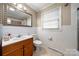 Clean bathroom with wood vanity, tiled walls, and a shower/tub combo at 117 Bolding St, Gastonia, NC 28052