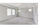 Bright bedroom with grey carpet and tray ceiling at 14950 Tamarack Dr, Charlotte, NC 28278