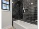 Bathroom with black tile, built-in shelf, and white bathtub at 2367 Lee Lawing Rd, Lincolnton, NC 28092