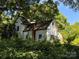 Older white house partially hidden by trees and vegetation at 0 Nc Hwy 73 W Hwy, Mount Gilead, NC 27306