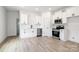 Modern kitchen with white cabinets, stainless steel appliances, and luxury vinyl plank flooring at 920 Holmes St, Salisbury, NC 28144