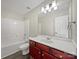 Clean bathroom with a white tub, vanity with wood cabinets, and a mirror at 3309 Paxton Ridge Dr, Indian Trail, NC 28079