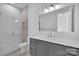 Bathroom with marble shower and gray vanity at 3500 Barclay Downs Dr, Charlotte, NC 28209
