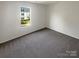 Spacious bedroom with gray carpet and large window at 4432 Eaves Ln, Charlotte, NC 28215