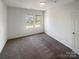 Bright bedroom featuring neutral carpeting and two large windows at 4432 Eaves Ln, Charlotte, NC 28215
