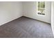 Simple bedroom with gray carpet and large window at 4432 Eaves Ln, Charlotte, NC 28215
