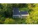 An elevated view of a contemporary home with large windows, set amidst trees at 9224 Maggie Robinson Rd, Waxhaw, NC 28173