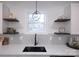 Kitchen features floating shelves, white cabinets, and black faucet at 615 English St, Monroe, NC 28110
