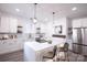 Modern white kitchen with island, stainless steel appliances, and stylish light fixtures at 615 English St, Monroe, NC 28110