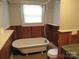 Bathroom with clawfoot tub, shower, and wood paneling at 1146 Buffalo St, Shelby, NC 28150