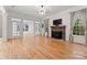 Living room with hardwood floors, stone fireplace, and built-in shelving at 124 Streamwood Rd, Troutman, NC 28166