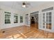 Bright sunroom with hardwood floors, multiple windows, and French doors leading to the living room at 124 Streamwood Rd, Troutman, NC 28166