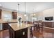 Open kitchen with island, stainless steel appliances, and dark wood cabinets at 5601 Ballenger Ct, Waxhaw, NC 28173