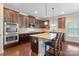 Modern kitchen with dark wood cabinets, granite island, and stainless steel appliances at 5601 Ballenger Ct, Waxhaw, NC 28173