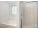 Bathroom with bathtub, shower, and window at 8310 Wallace Glen Dr, Charlotte, NC 28212