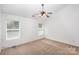 Spacious bedroom with ceiling fan, carpet, and two windows at 8310 Wallace Glen Dr, Charlotte, NC 28212