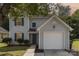 Two-story house with gray siding, a white garage door, and landscaping at 8310 Wallace Glen Dr, Charlotte, NC 28212