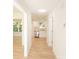 Light-filled hallway with wood-look floors, leading to kitchen and other rooms at 830 Oakshire Cir, Charlotte, NC 28214