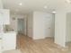Open living room with light wood-look flooring and access to kitchen at 830 Oakshire Cir, Charlotte, NC 28214