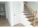 Wooden staircase with black metal balusters and a white door at 830 Oakshire Cir, Charlotte, NC 28214